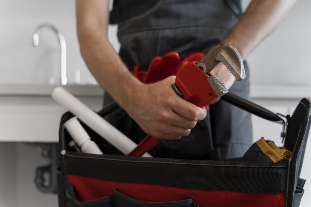 Close up of a plumber holding a red toolbox