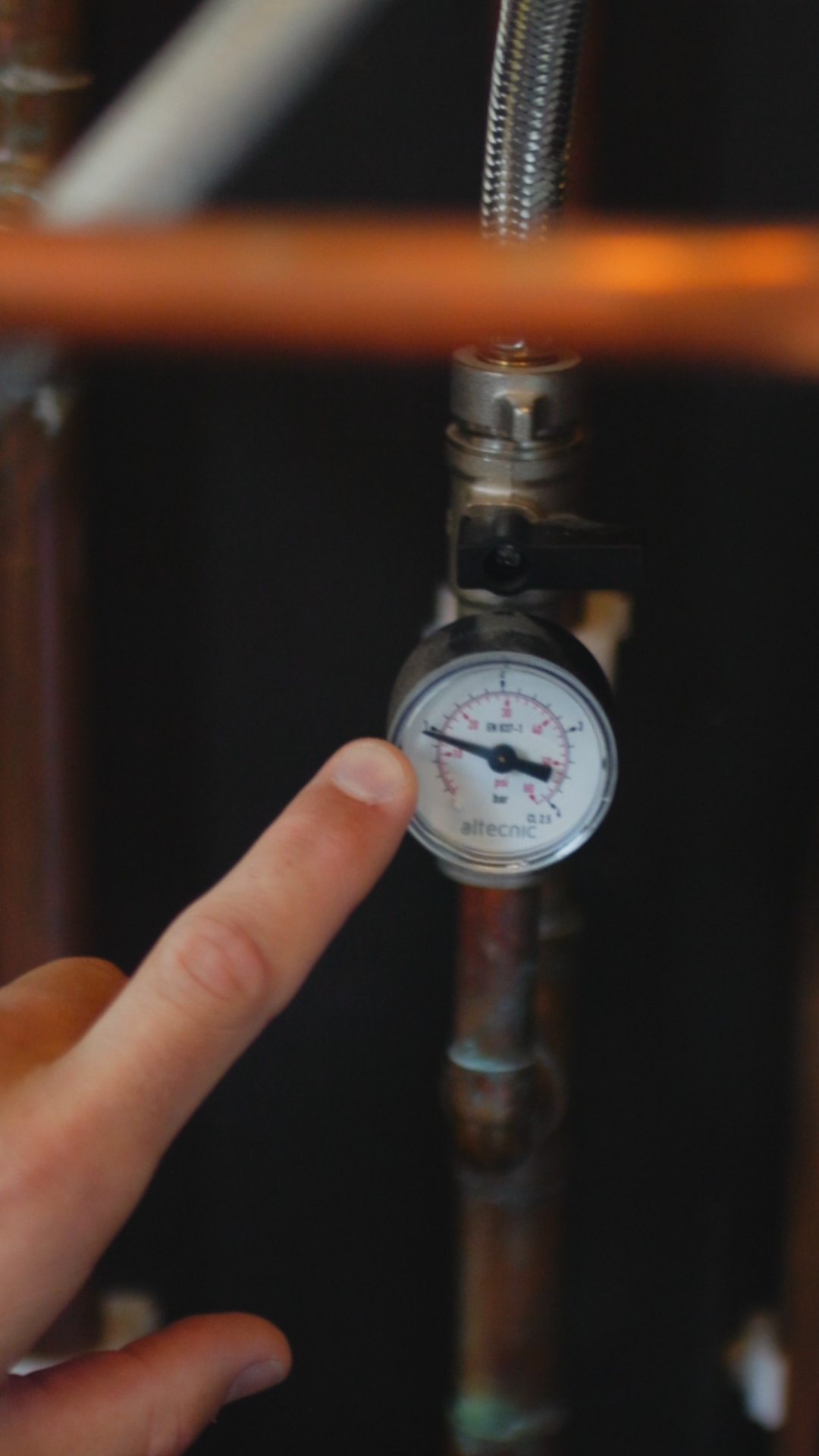 Plumbing on demand photo of a finger pointing at a valve