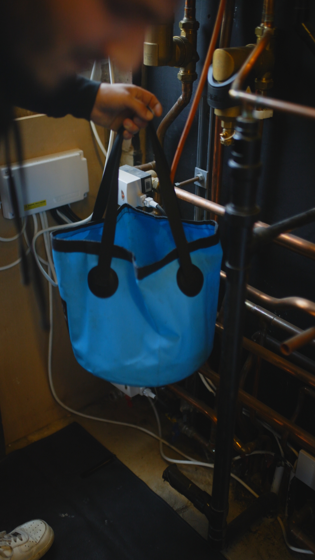 Plumbing on demand on a job with a blue electrical bag