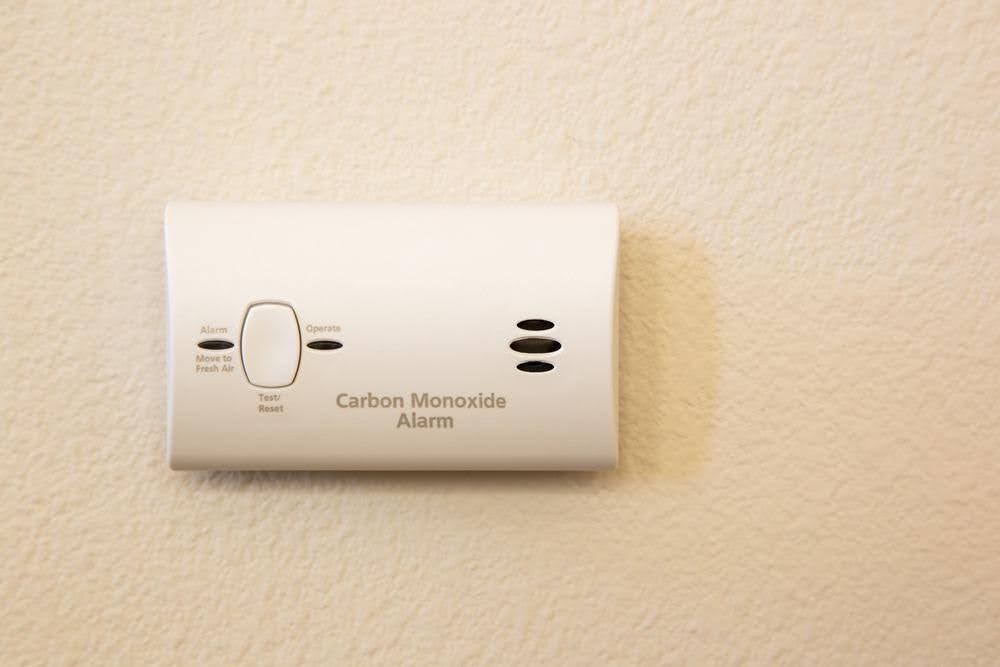 White carbon monoxide alarm on a cream wall